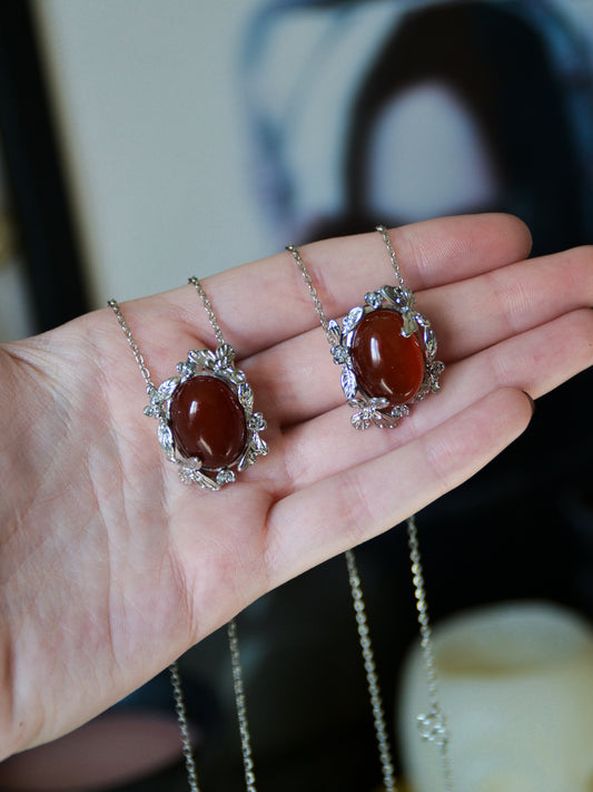 Ciondolo con montatura floreale e di farfalle con agata rossa